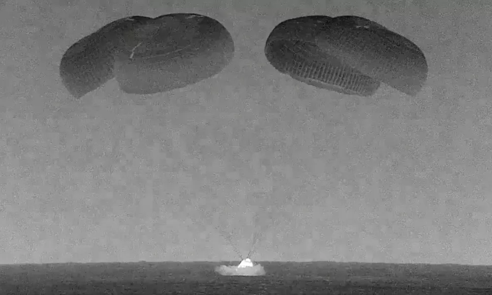 This black and white, thermal image made from SpaceX video shows its capsule, center, carrying tech entrepreneur Jared Isaacman with his crew as it splashes down in the Gulf of Mexico near Florida's Dry Tortugas early Sunday, Sept. 15, 2024. (SpaceX via AP)