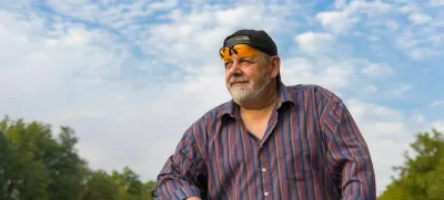 Outdoor portrait of a bearded senior man getting ready to ride on a bicycle / Foto: Yurikr