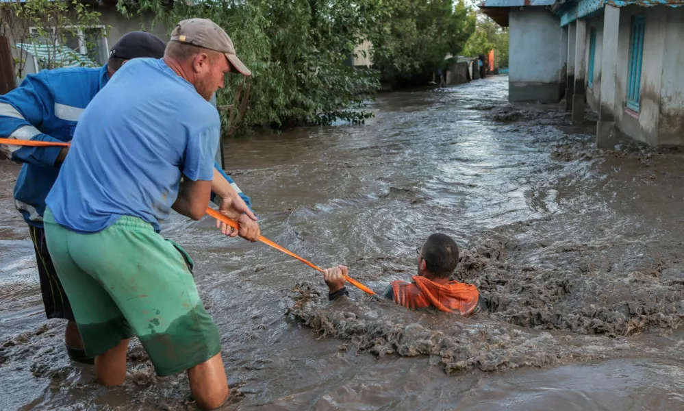 Locals and rescuers pull a man through flood water, after heavy rain triggered flooding in Slobozia Conachi, Galati country, Romania, September 14, 2024. Inquam Photos/George Calin via REUTERS ATTENTION EDITORS - THIS IMAGE WAS PROVIDED BY A THIRD PARTY. ROMANIA OUT. NO COMMERCIAL OR EDITORIAL SALES IN ROMANIA