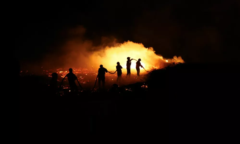 Firefighters try to extinguish a wildfire in Canas de Senhorim, Portugal, September 16, 2024. REUTERS/Pedro Nunes