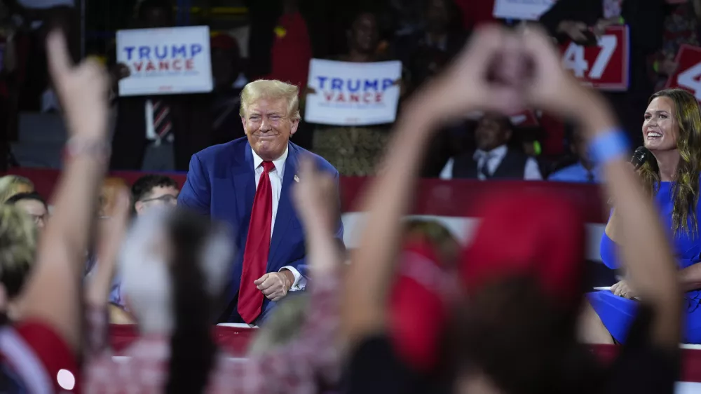 Republican presidential candidate former President Donald Trump, left, on stage with Arkansas Gov. Sarah Huckabee Sanders, right, during a town hall event at the Dort Financial Center, Tuesday, Sept. 17, 2024, in Flint, Mich. (AP Photo/Evan Vucci)