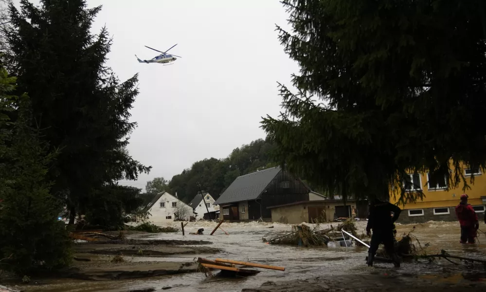 A helicopter hovers over flooded houses in Jesenik, Czech Republic, Sunday, Sept. 15, 2024. (AP Photo/Petr David Josek)