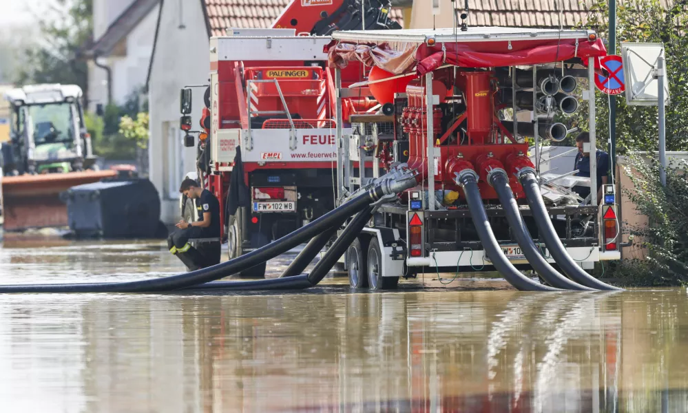 18 September 2024, Austria, Erpersdorf: In Kleinschoenbichl, the flood waters are still in many parts of the village and the fire department is using pumps to remove water from roads and fields. In Austria, the flood waters are receding slightly, but the situation remains tense and there is still a threat of dam failures and landslides. Photo: Christoph Reichwein/dpa