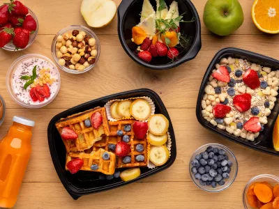 Organic breakfast meal delivery in plastic containers, top view