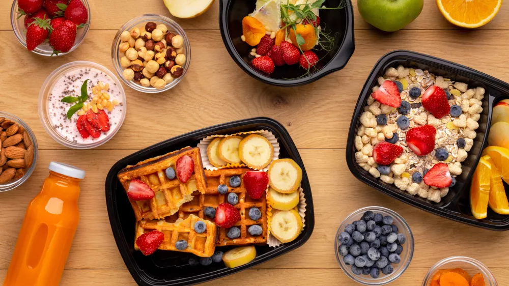 Organic breakfast meal delivery in plastic containers, top view