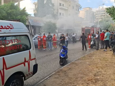 Smoke rises from a mobile shop as civil defence members gather in Sidon, Lebanon September 18, 2024. REUTERS/Hassan Hankir