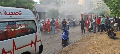 Smoke rises from a mobile shop as civil defence members gather in Sidon, Lebanon September 18, 2024. REUTERS/Hassan Hankir