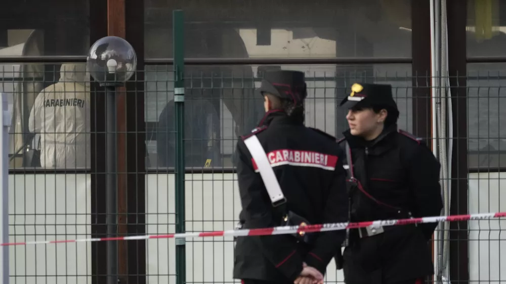 Italian Carabinieri patrol in front of a bar where three people died after a man entered and shot in Rome, Sunday, Dec. 11, 2022. (AP Photo/Gregorio Borgia)