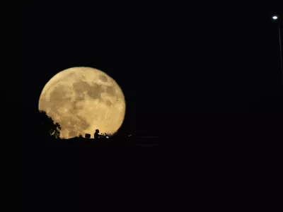 The moon rises in the sky over a freeway as drivers pass between Haifa and Tel Aviv, Israel, Wednesday, Sept. 18, 2024. (AP Photo/Ariel Schalit)