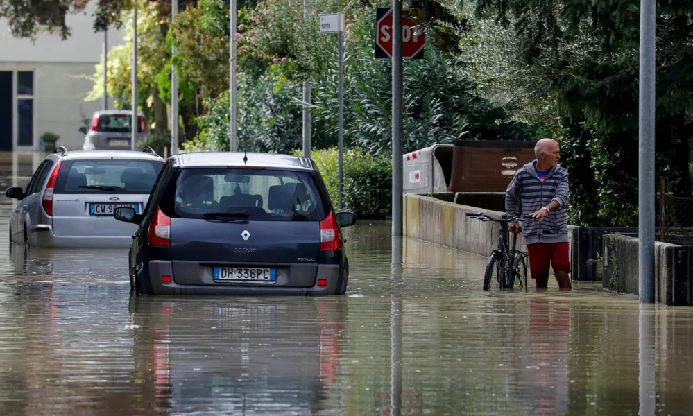 A man holds a bicycle as he stands in a flooded street, as the Emilia-Romagna region experiences floods triggered by severe weather, in Lugo, Emilia-Romagna, Italy, September 20, 2024. REUTERS/Ciro de Luca