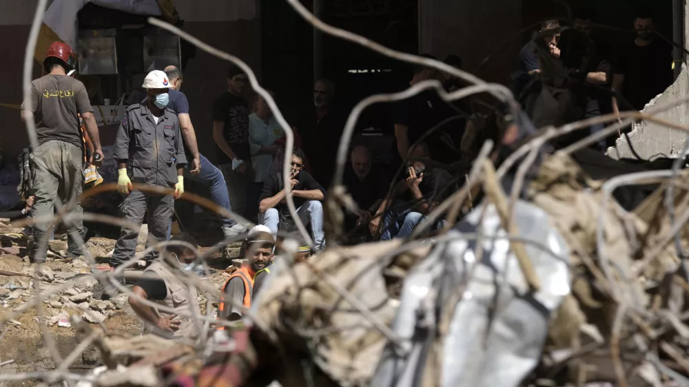 Emergency workers clear the rubble at the site of Friday's Israeli strike in Beirut's southern suburb, Sunday, Sept. 22, 2024. (AP Photo/Bilal Hussein)