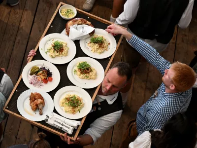 A waiter carries food on the day of the official opening of the 189th Oktoberfest, the world's largest beer festival in Munich, Germany, September 21, 2024. REUTERS/Angelika Warmuth