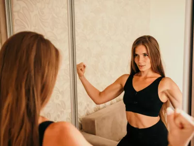 Young woman with long hair, fitness instructor in black sportswear, doing stretching and pilates on yoga mat at home. Female fitness yoga routine concept. Healthy lifestyle harmony and meditation / Foto: Panophotograph