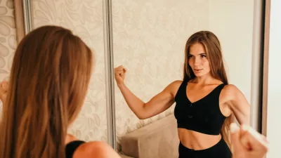 Young woman with long hair, fitness instructor in black sportswear, doing stretching and pilates on yoga mat at home. Female fitness yoga routine concept. Healthy lifestyle harmony and meditation / Foto: Panophotograph