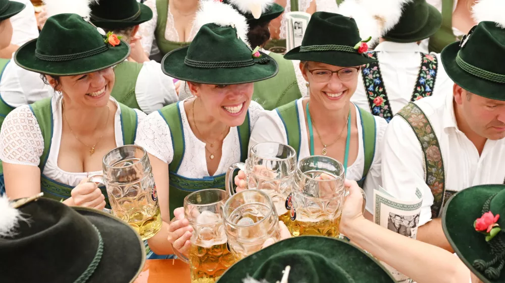 People dressed in traditional clothes sit in a tent during the 189th Oktoberfest, the world's largest beer festival in Munich, Germany, September 22, 2024. REUTERS/Angelika Warmuth