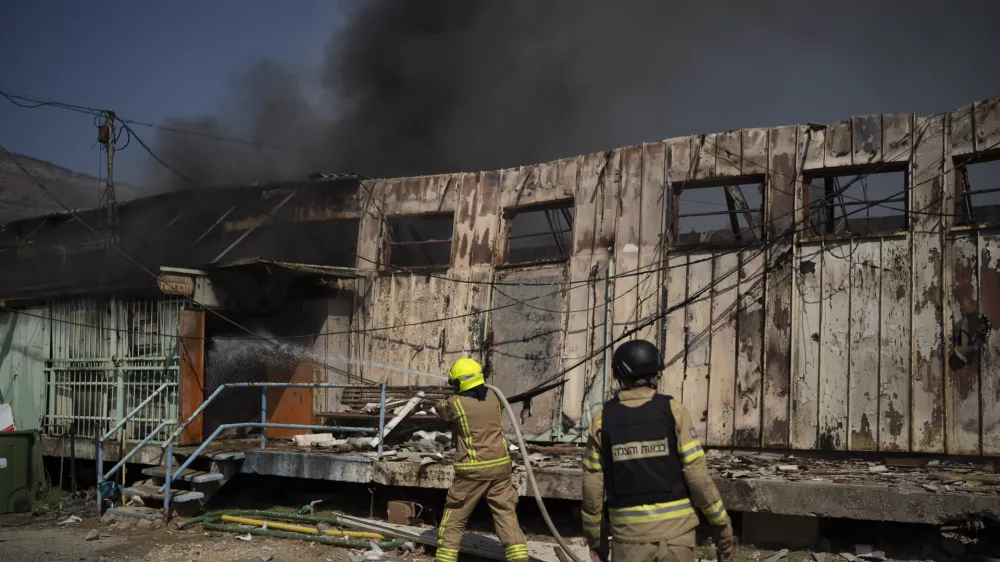 Firefighters work to extinguish a fire after a rocket, fired from Lebanon, hit a local municipality storage in Kiryat Shmona, northern Israel, Tuesday, Sept. 24, 2024. (AP Photo/Leo Correa)