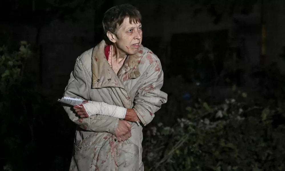 An injured woman is seen next to her apartment building damaged by a Russian air strike, amid Russia's attack on Ukraine, in Zaporizhzhia, Ukraine September 23, 2024. REUTERS/Stringer