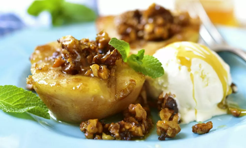 Grilled pear with caramelized walnuts and honey on a blue vintage plate. / Foto: Lilechka75