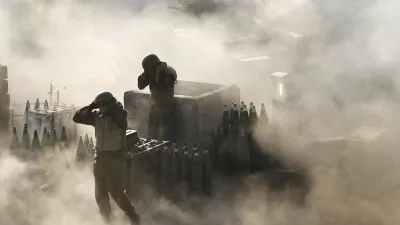 Israeli artillery soldiers are surrounded by smoke and dust as they fire across the border into southern Lebanon from a position on the frontier in Zaura, northern Israel, on July 12, 2006. (AP Photo/Oded Balilty, File)