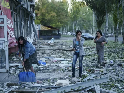 People clear the rubble in a front of a residential building heavily damaged after a Russian airstrike in Kramatorsk, Donetsk region, Ukraine, Wednesday, Sept. 25, 2024. (AP Photo/Evgeniy Maloletka)