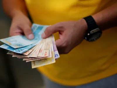 FILE PHOTO: A man counts betting money while watching the round of 16 soccer match for the 2014 World Cup between Brazil and Chile, during a gathering in a home in the upper class neighborhood of Lago Sul in Brasilia, June 28, 2014. REUTERS/Ueslei Marcelino/File Photo