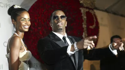 FILE - Sean "P. Diddy" Combs directs photographers as they sing "Happy Birthday," to him as his date Kim Porter, left, listens, after Combs arrived for his 35th birthday celebration at Cipriani on Wall Street in New York, Nov. 4, 2004. (AP Photo/Kathy Willens, File)