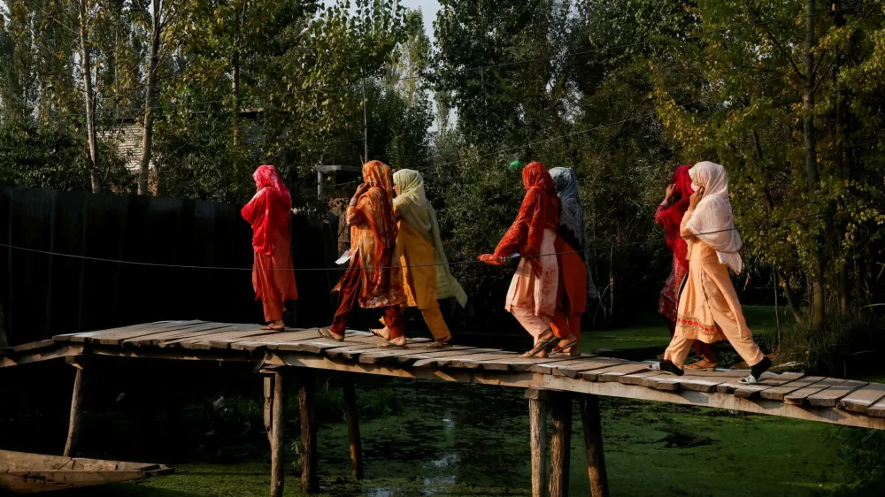 Kashmiri women walk to vote at a polling station, during the second phase of assembly elections, in Srinagar September 25, 2024. REUTERS/Sharafat Ali   TPX IMAGES OF THE DAY