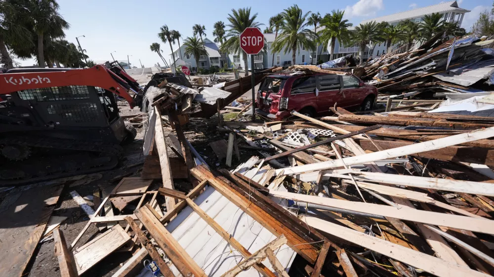 Workers clear debris in the aftermath of Hurricane Helene, in Cedar Key, Fla., Friday, Sept. 27, 2024. (AP Photo/Gerald Herbert)