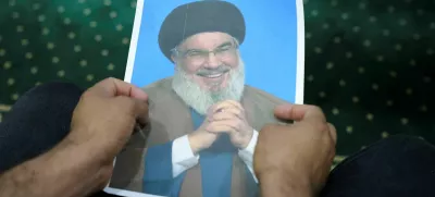 An Iraqi volunteer holds a picture of Lebanon's Hezbollah leader Sayyed Hassan Nasrallah, who has been killed, while registering his name to support Hezbollah, following a call from the Jihad and Construction Movement, a Shi'a Islamist Iraqi political party, in Basra, Iraq, on September 27, 2024. REUTERS/Essam al-Sudani