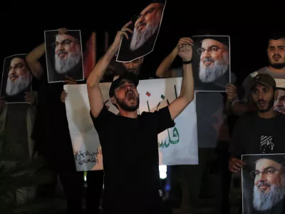 Lebanese and Palestinian men hold portraits of Hezbollah leader Sayyed Hassan Nasrallah, as they shout slogans during a protest in the southern port city of Sidon, Lebanon, Saturday, Sept. 28, 2024. (AP Photo/Hussein Malla)