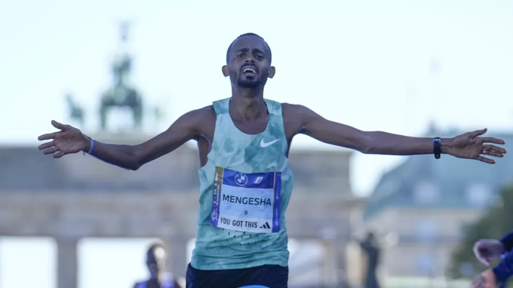 Milkesa Mengesha from Ethiopia celebrates as he crosses the finish line to win the men's division of the Berlin Marathon in Berlin, Germany, Sunday, Sept. 29, 2024. (AP Photo/Ebrahim Noroozi)