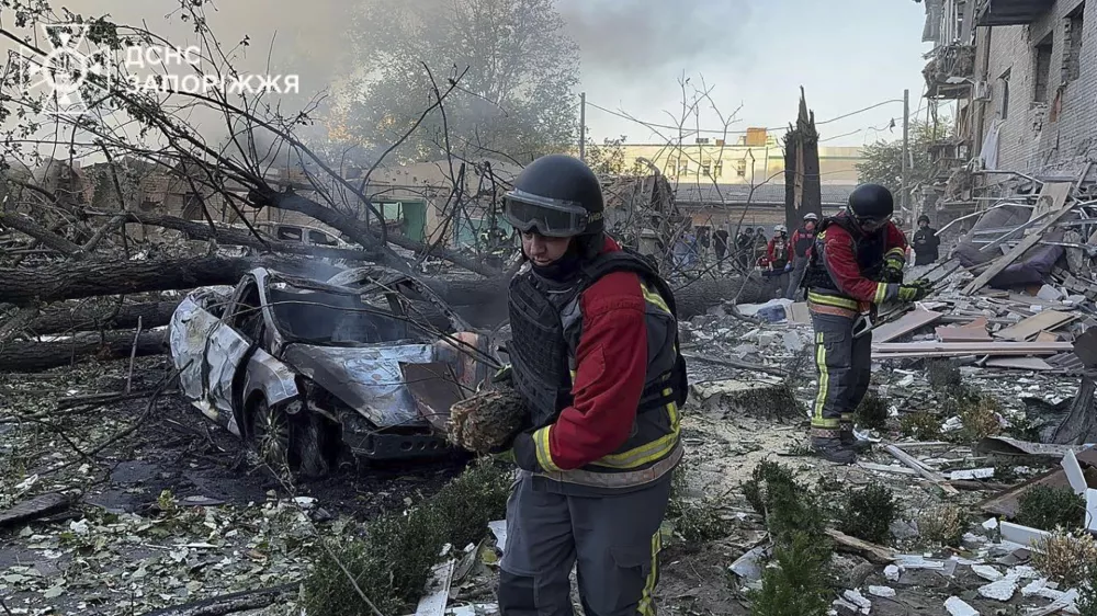 In this photo provided by the Ukrainian Emergency Service, emergency workers clear the rubble after Russia attacked the city with guided bombs overnight in Zaporizhzhia, Ukraine, Sunday, Sept. 29, 2024. (Ukrainian Emergency Service via AP)