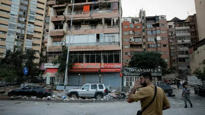 People pass by buildings damaged in an Israeli strike, amid ongoing cross-border hostilities between Hezbollah and Israeli forces, in Kola, central Beirut, Lebanon September 30, 2024. REUTERS/Louisa Gouliamaki