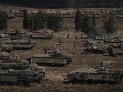 Israeli soldiers work on tanks and armoured personnel carriers (APC) in northern Israel, Monday, Sept. 30, 2024. (AP Photo/Leo Correa)