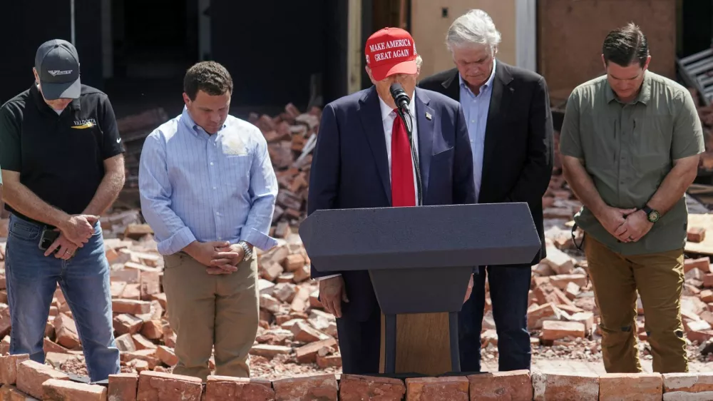 Republican presidential nominee and former U.S. President Donald Trump stands during a moment of silence at an event about the damage caused by Hurricane Helene, in Valdosta, Georgia, U.S., September 30, 2024. REUTERS/Elijah Nouvelage   TPX IMAGES OF THE DAY