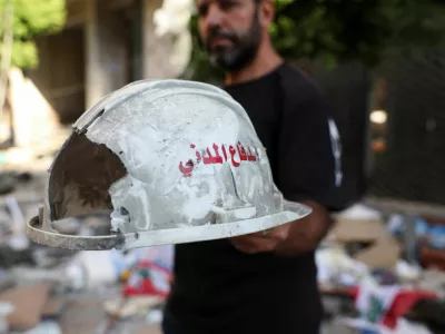 A man holds up a damaged helmet that reads "Civil Defense", following an Israeli strike on central Beirut's Bachoura neighbourhood, amid ongoing hostilities between Hezbollah and Israeli forces, in Beirut, Lebanon October 3, 2024. REUTERS/Emilie Madi