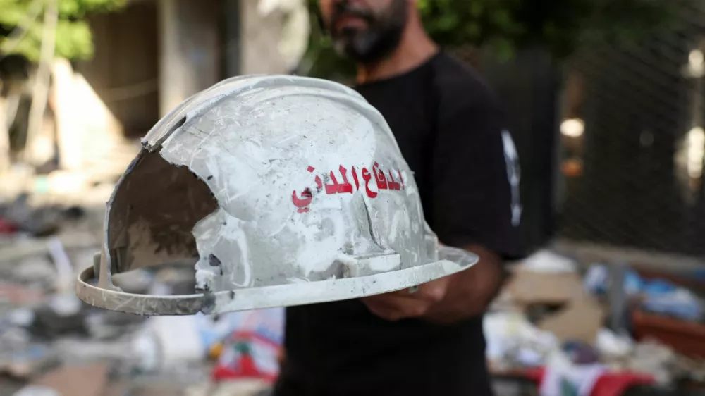 A man holds up a damaged helmet that reads "Civil Defense", following an Israeli strike on central Beirut's Bachoura neighbourhood, amid ongoing hostilities between Hezbollah and Israeli forces, in Beirut, Lebanon October 3, 2024. REUTERS/Emilie Madi