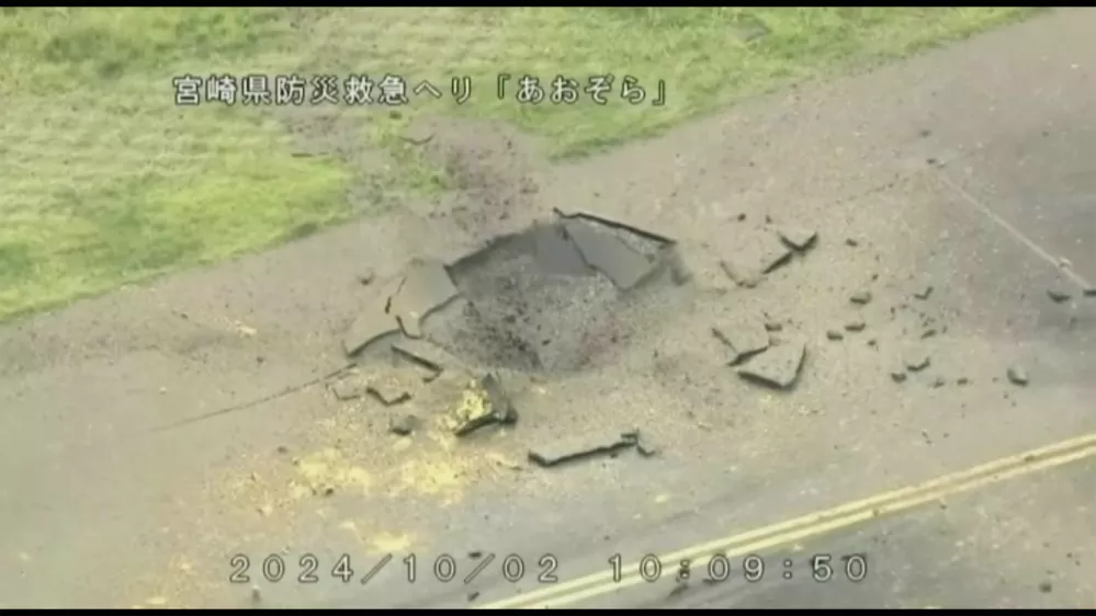 This image from video taken from a helicopter of Miyazaki Prefecture shows part of a damaged taxiway at Miyazaki Airport in southwestern Japan, Wednesday, Oct. 2, 2024, after an explosion was reported. The words at top read: Miyazaki Prefecture Disaster Prevention and Emergency Care Helicopter Aozora. (Miyazaki Prefecture via AP)