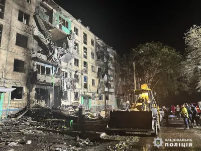 People gather around the damage and debris after a Russian strike on a residential building in Kharkiv, Ukraine, late Wednesday Oct. 2, 2024. (Ukrainian National Police via AP)