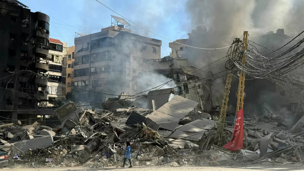 A woman walks past damaged buildings and debris in the aftermath of a strike, amid ongoing hostilities between Hezbollah and Israeli forces, in Beirut's southern suburbs, Lebanon October 3, 2024. REUTERS/Mohamed Azakir   TPX IMAGES OF THE DAY