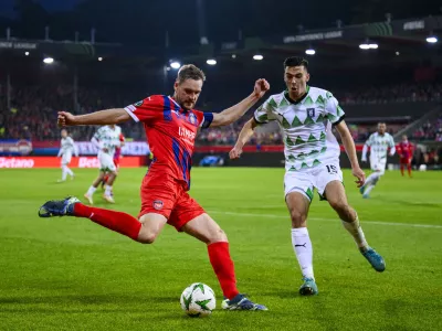 Heidenheim's Patrick Mainka, left, in action against Ljubljana's Marko Ristic during the Conference League soccer match between 1. FC Heidenheim and Olimpija Ljubljana in Heidenheim, Germany, Thursday, Oct. 3, 2024. (Tom Weller/dpa via AP)