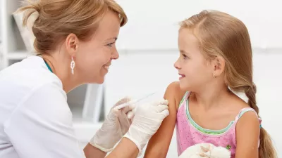 ﻿Brave little girl receiving injection or vaccine with a smile