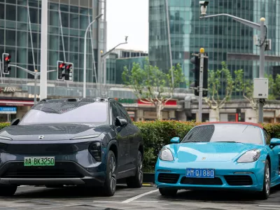 FILED - 23 June 2024, China, Shanghai: An electric car from the Chinese brand NIO and one from Porsche with a combustion engine are parked in a parking lot. European Union countries on Friday paved the way for additional tariffs of up to 35.3% on battery-powered electric vehicles imported from China, EU diplomats told dpa. Photo: Sebastian Christoph Gollnow/dpa