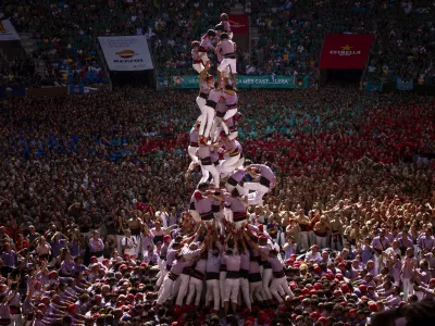 Members of "Colla Jove de Tarragona" fall before completing a "Castell" or human tower, during the 29th Human Tower Competition in Tarragona, Spain, Sunday, Oct. 6, 2024. (AP Photo/Emilio Morenatti)