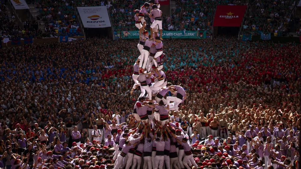 Members of "Colla Jove de Tarragona" fall before completing a "Castell" or human tower, during the 29th Human Tower Competition in Tarragona, Spain, Sunday, Oct. 6, 2024. (AP Photo/Emilio Morenatti)