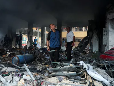 Palestinians inspect the site of an Israeli strike on a school sheltering displaced people, amid Israel-Hamas conflict, in Deir Al-Balah, in the central Gaza Strip, October 6, 2024. REUTERS/Ramadan Abed   TPX IMAGES OF THE DAY