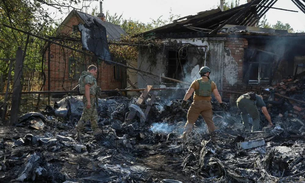 Ukrainian service members inspect parts of a Russian aerial vehicle, which local authorities assume to be a newest heavy unmanned aerial vehicle S-70 Okhotnik (Hunter) or variation of Sukhoi fighting jet, is seen in residential area of the town of Kostintynivka after it was shot down, amid Russia's attack on Ukraine, in Donetsk region, Ukraine October 5, 2024. Radio Free Europe/Radio Liberty/Serhii Nuzhnenko via REUTERS  THIS IMAGE HAS BEEN SUPPLIED BY A THIRD PARTY