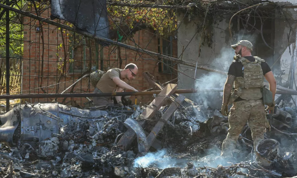 Ukrainian service members inspect parts of a Russian aerial vehicle, which local authorities assume to be a newest heavy unmanned aerial vehicle S-70 Okhotnik (Hunter) or variation of Sukhoi fighting jet, is seen in residential area of the town of Kostintynivka after it was shot down, amid Russia's attack on Ukraine, in Donetsk region, Ukraine October 5, 2024. Radio Free Europe/Radio Liberty/Serhii Nuzhnenko via REUTERS