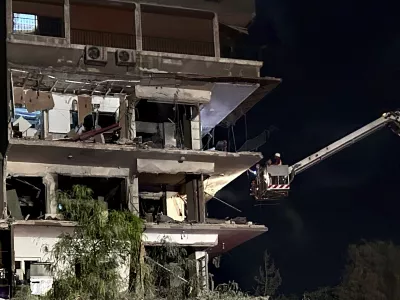 Rescue workers on a crane check a damaged building hit by an Israeli strike in Damascus, Syria, Tuesday, Oct. 8, 2024. (AP Photo/Omar Sanadiki)