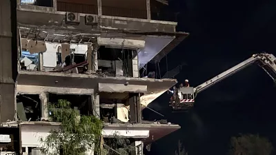 Rescue workers on a crane check a damaged building hit by an Israeli strike in Damascus, Syria, Tuesday, Oct. 8, 2024. (AP Photo/Omar Sanadiki)